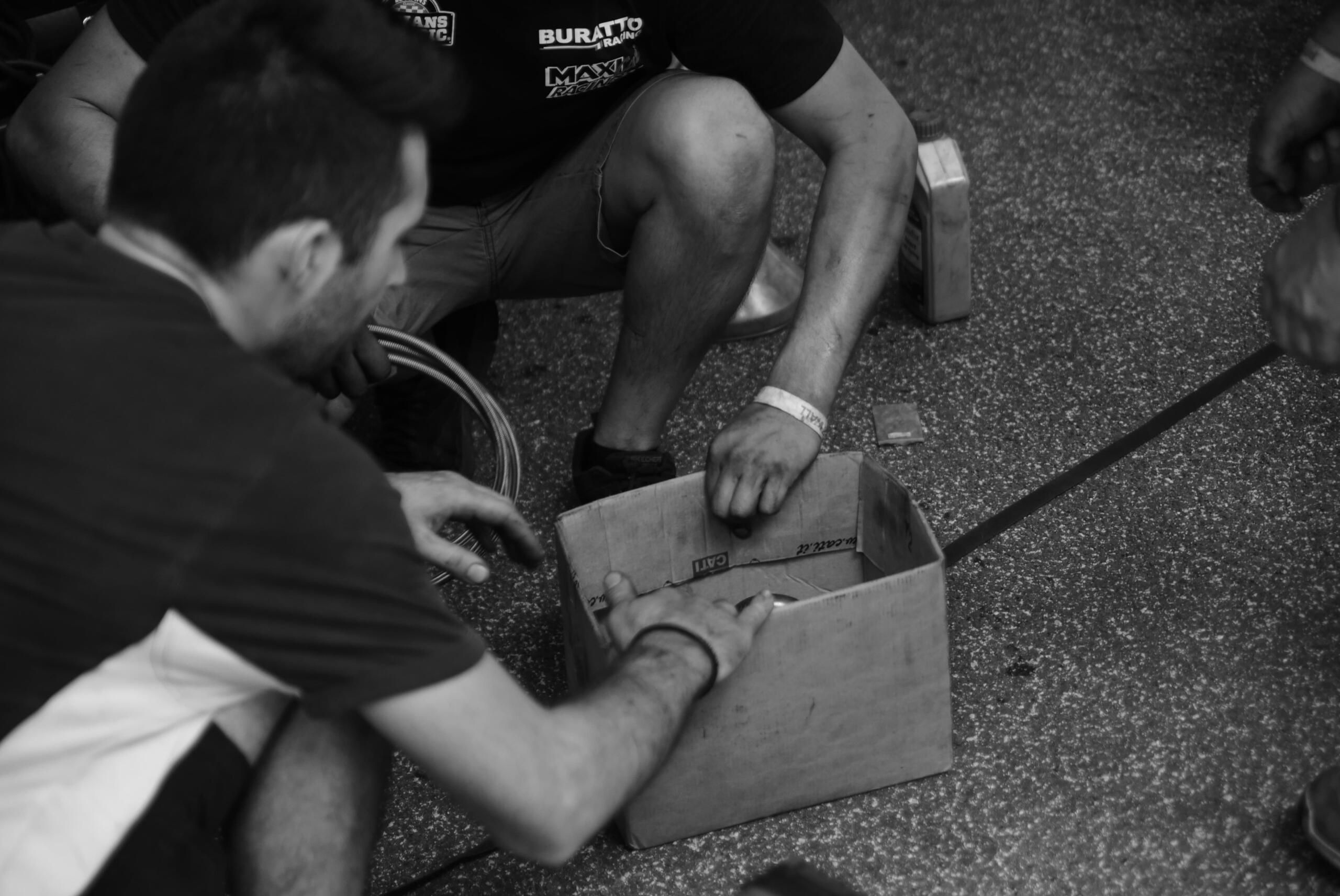 Meccanici che cercano urgentemente un bullone mancante